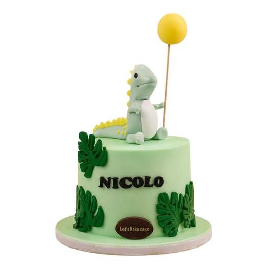 A cute mint green birthday cake with a handcrafted dinosaur topper holding a yellow balloon and tropical leaves by Let's Bake Cake Abu Dhabi