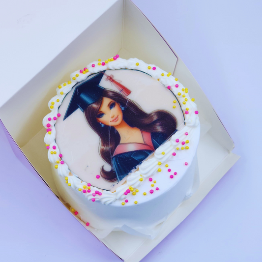 A luxury white graduation cake with a Barbie edible image, pink and gold sprinkles by Let's Bake Cake Abu Dhabi