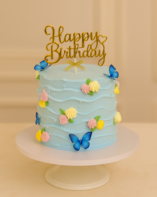 A luxury light blue textured wave cake with pastel pink and yellow flowers and blue butterflies by Let's Bake Cake Abu Dhabi.