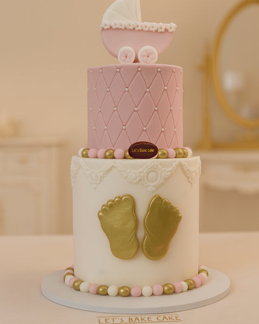 A luxury two-tier baby shower cake with pink quilted pattern, gold baby feet, and a pink pram topper by Let's Bake Cake Abu Dhabi