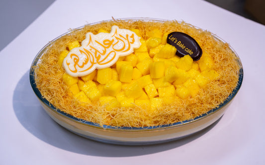 A luxury Mango Kunafa Trifle in a glass dish, topped with fresh mango cubes and crispy golden kunafa, featuring a festive Ramadan chocolate topper by Let's Bake Cake, Abu Dhabi.