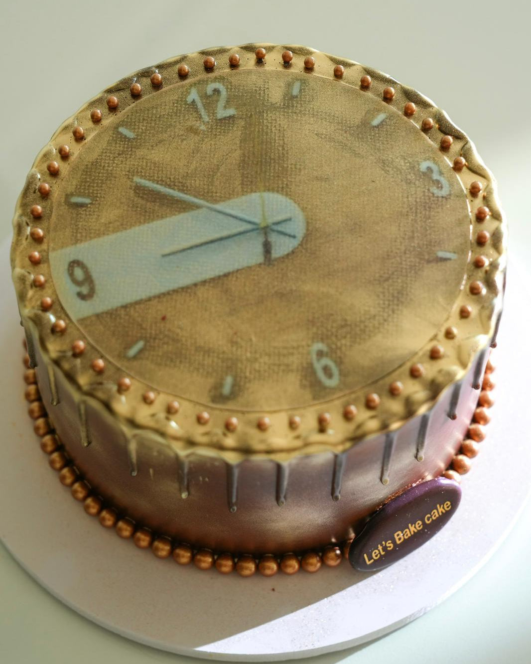 Cake decorated like a clock with gold accents and number details.