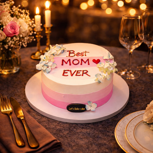 A premium pink ombre celebration cake with 'Best MOM Ever' written on top, decorated with small flowers, set on a luxury dinner table with candles in Abu Dhabi, by Let's Bake Cake.