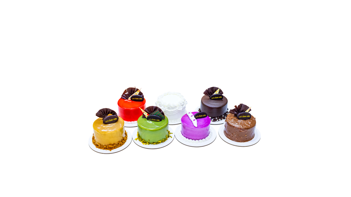 A colorful assortment of mini bento cakes including Lotus, Pistachio, Chocolate, and Red Velvet flavors, handcrafted by Let's Bake Cake with same-day delivery in Abu Dhabi.