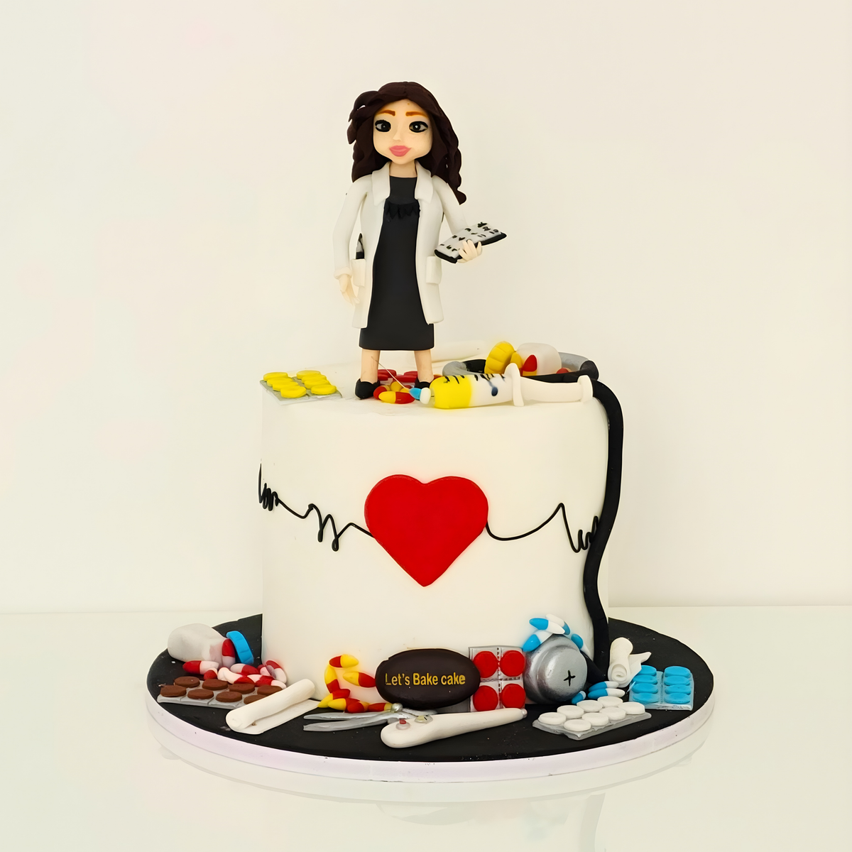 A premium custom medical theme cake featuring a female doctor fondant topper, stethoscope, pills, and a red heart with ECG line by Let's Bake Cake Abu Dhabi.