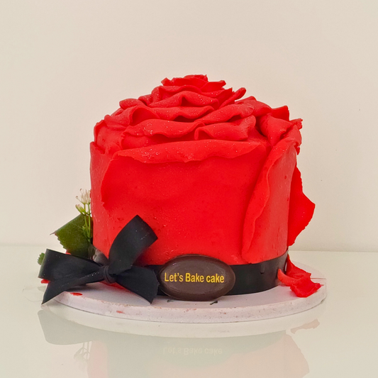 A luxury 3D sculpted red rose cake decorated with a black ribbon and bow by Let's Bake Cake Abu Dhabi