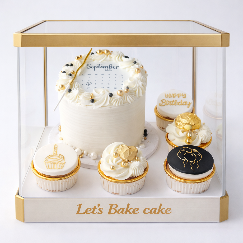 A luxury birthday gift set featuring a white calendar cake and five matching cupcakes inside a gold-framed transparent acrylic box by Let's Bake Cake Abu Dhabi