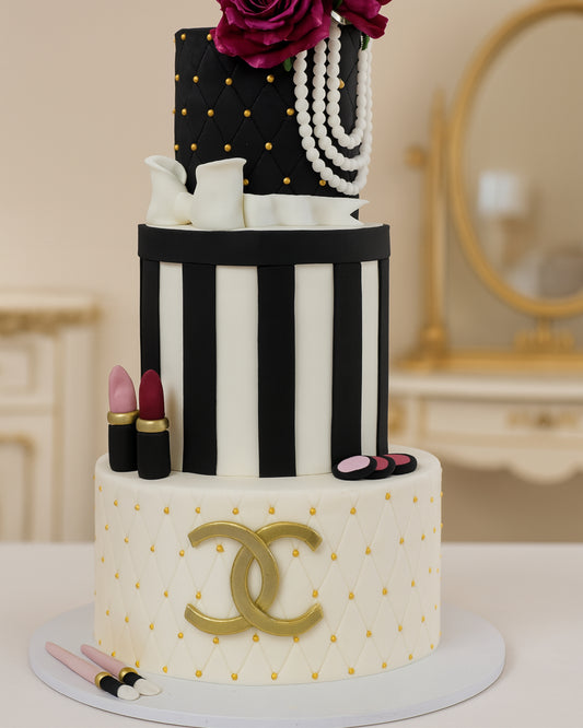 A luxury three-tier Chanel-inspired fashion cake with makeup decorations, pearls, and a gold logo by Let's Bake Cake Abu Dhabi.
