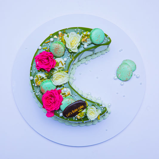 A luxury chocolate mirror-glazed crescent moon cake decorated with Ferrero Rocher, fresh strawberries, chocolate macaroons, and gold leaf by Let's Bake Cake Abu Dhabi.