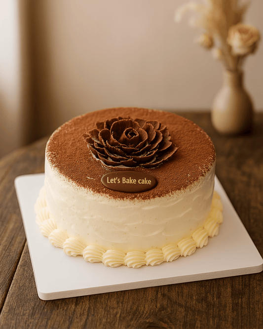A luxury cream cake with cocoa dusting and a handcrafted chocolate rose topper by Let's Bake Cake Abu Dhabi.