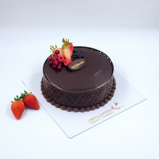 A luxury dark chocolate ganache cake featuring an intricate chocolate lace collar and fresh berries by Let's Bake Cake Abu Dhabi.