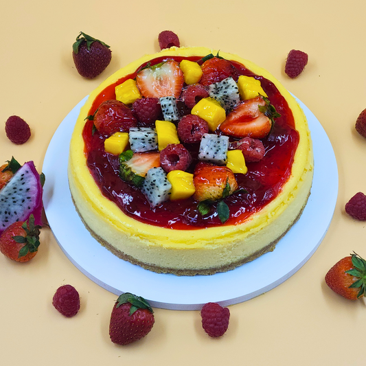 A luxury New York cheesecake topped with fresh dragon fruit, mango, strawberries, and raspberries by Let's Bake Cake Abu Dhabi.