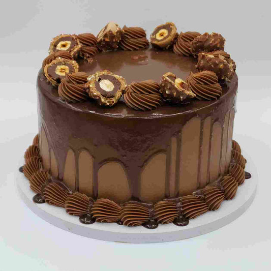 A luxury chocolate drip cake topped with Ferrero Rocher chocolates and chocolate buttercream swirls by Let's Bake Cake Abu Dhabi.