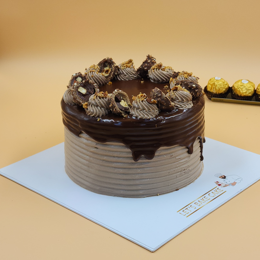 A luxury Ferrero Rocher chocolate drip cake with hazelnut cream and gold-wrapped chocolates in the background by Let's Bake Cake Abu Dhabi.