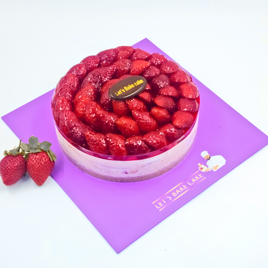 A luxury fresh strawberry glazed cake on a purple Let's Bake Cake board with whole strawberries on the side.