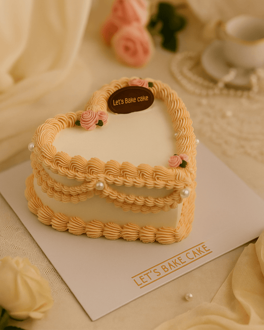 A luxury ivory heart-shaped vintage piped cake with peach ruffles, mini roses, and large pearls by Let's Bake Cake Abu Dhabi.