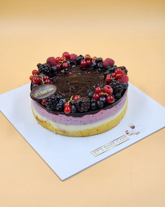 A luxury layered mixed berry mousse cake topped with fresh blackberries, raspberries, and red currants by Let's Bake Cake Abu Dhabi.