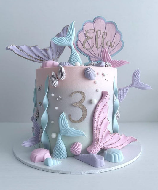 A luxury pastel ombré mermaid-themed birthday cake with shimmering tails and seashells by Let's Bake Cake Abu Dhabi