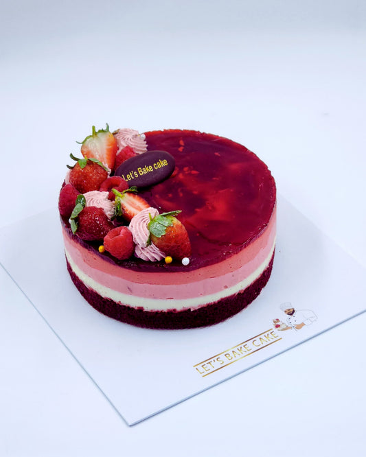 A luxury multi-layered mixed berry mousse cake with ombre layers, fresh strawberries, and raspberries by Let's Bake Cake Abu Dhabi.