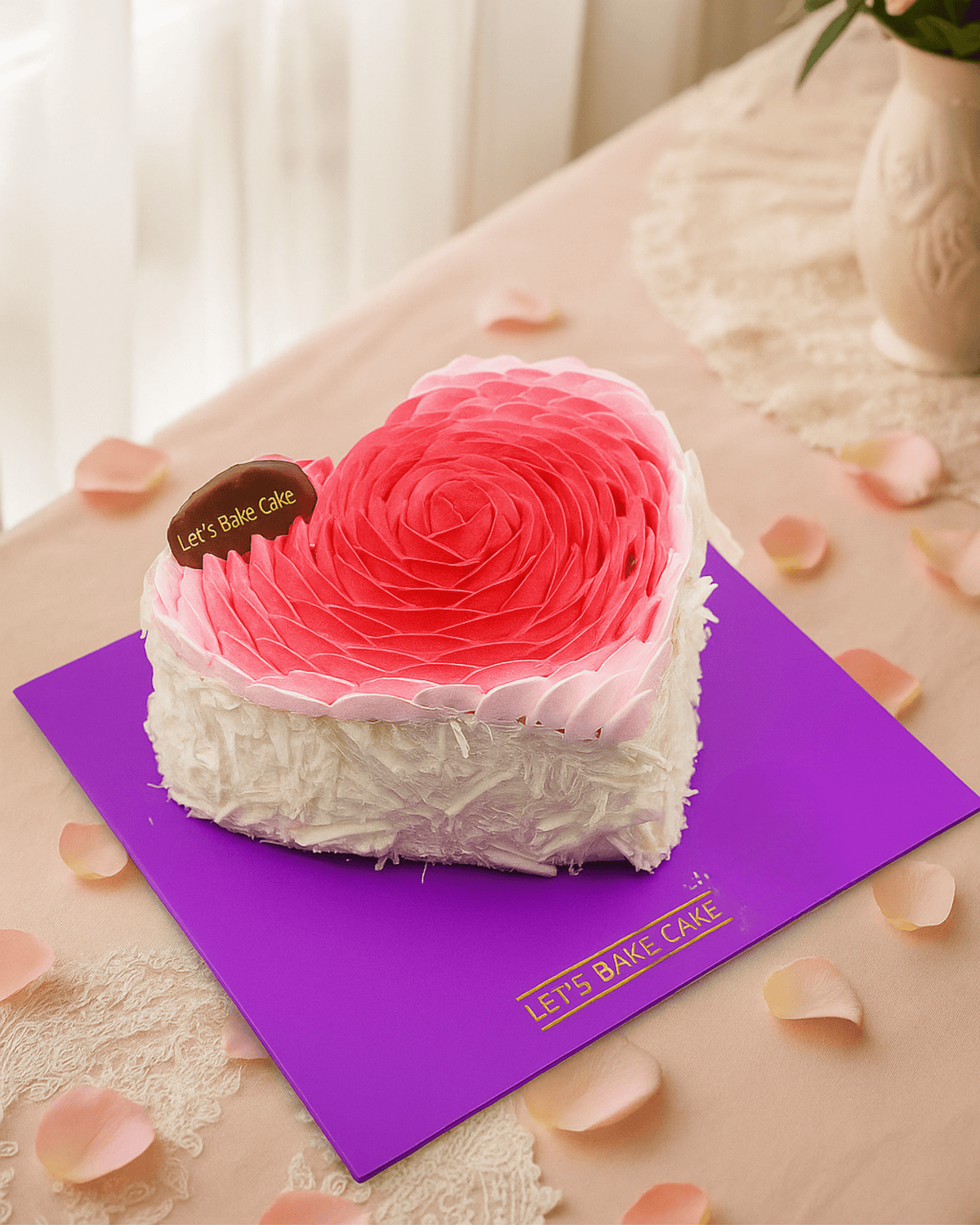 A luxury heart-shaped cake with a large pink ombre rosette top and white chocolate shavings on the sides by Let's Bake Cake Abu Dhabi.