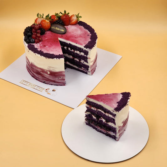 A luxury purple velvet layered cake with white cream frosting, topped with fresh strawberries and blueberries by Let's Bake Cake Abu Dhabi.