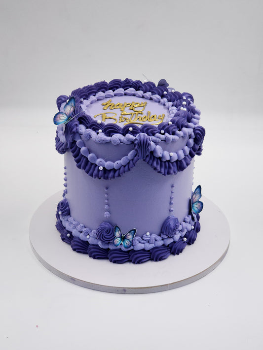 A luxury purple and lavender vintage Lambeth-style piped birthday cake with edible butterflies and gold topper by Let's Bake Cake Abu Dhabi.