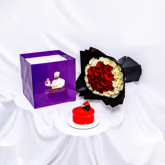 A luxury romantic gift set featuring a vibrant red glazed bento cake, a heart-shaped red and white rose bouquet in black premium wrap, and a branded 'Let's Bake Cake' purple gift bag on white silk, Abu Dhabi