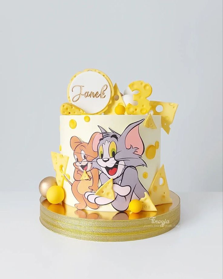 A playful Tom and Jerry themed birthday cake with 3D cheese slices and a personalized name plaque by Let's Bake Cake Abu Dhabi.