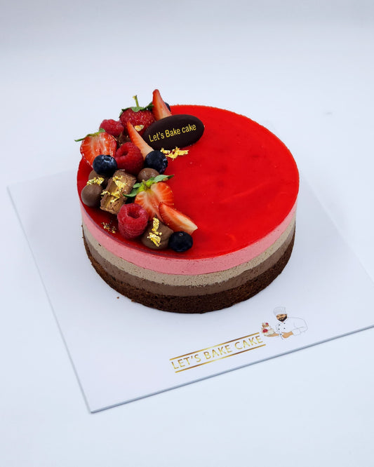A luxury triple-layer chocolate and raspberry mousse cake topped with fresh berries and gold leaf by Let's Bake Cake Abu Dhabi.