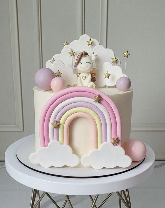 A luxury pastel unicorn and rainbow-themed birthday cake with fluffy clouds and gold stars by Let's Bake Cake Abu Dhabi.