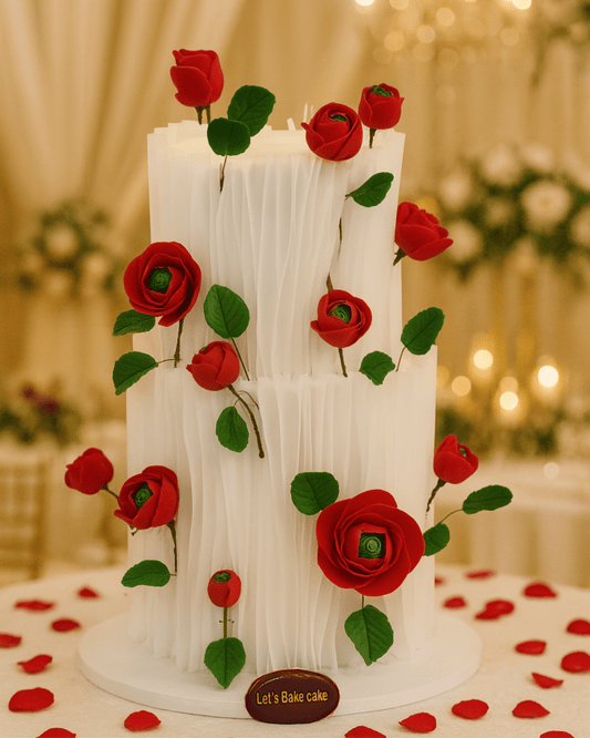 A luxury two-tier wedding cake with white vertical ruffles and handcrafted red roses by Let's Bake Cake Abu Dhabi.